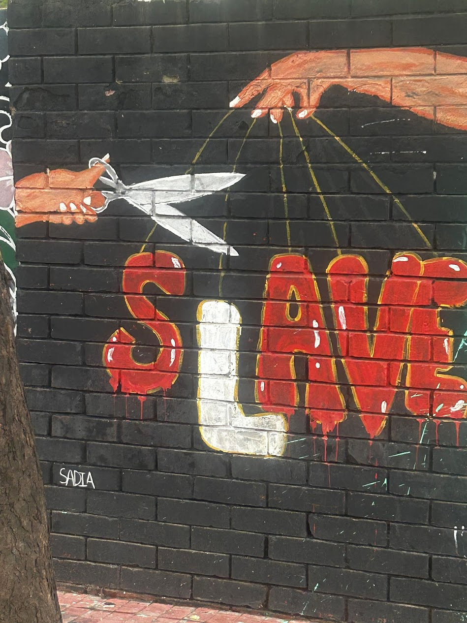SLAVE mural with hand cutting puppet strings — Dhaka street art
